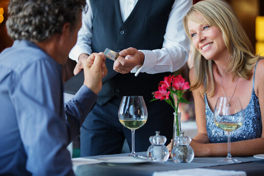 Man Paying With Credit Card In Restaurant