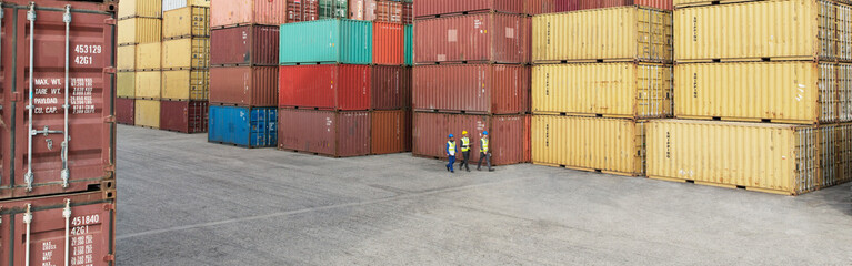 Fototapeta premium Workers walking near cargo containers