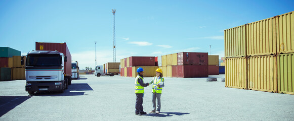 Workers talking near cargo containers