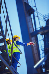 Fototapeta na wymiar Low angle view of workers on cargo crane
