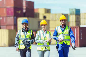 Businesswoman and workers walking near cargo containers