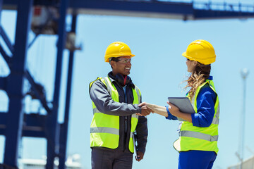 Fototapeta na wymiar Worker and businessman shaking hands near cargo crane