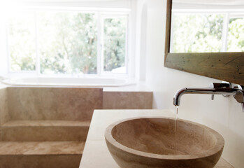 Modern bathroom interior with stone sink and bathtub