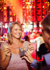 Man handing gift to woman in bar