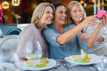 Female friends taking selfie in restaurant