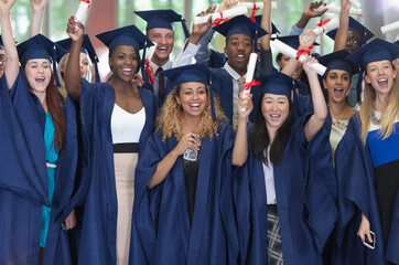 Group of students in graduation clothes posing together for group portrait