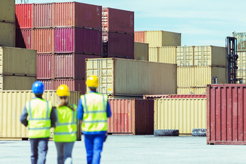 Workers and businessman walking near cargo containers