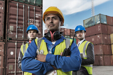 Worker and businessmen standing near cargo containers