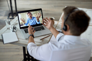 Two business colleagues discussing while having online meeting over a computer.