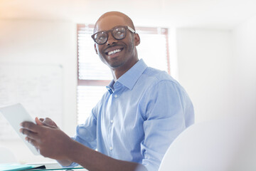 Portrait young businessman wearing glasses blue shirt holding digital tablet in office