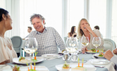 Cheerful people laughing at restaurant table