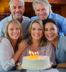 Portrait of smiling mature men and women with birthday cake