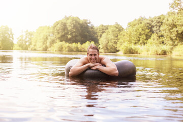 Man floating in inner tube in lake