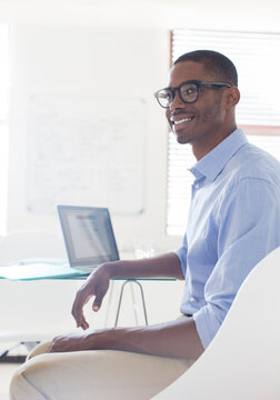 Portrait Young Smiling Man Wearing Glasses Blue Shirt Sitting At Desk Laptop