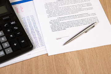 Obraz premium A part of contract or agreement document, space of signature with a silver pen and calculator.