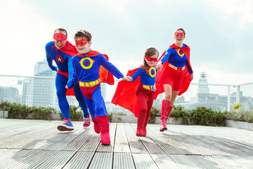 Superhero family playing on city rooftop