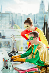 Superheroes working on laptop in office