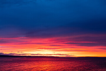 Obraz premium The golden rays of sunset over the ocean water