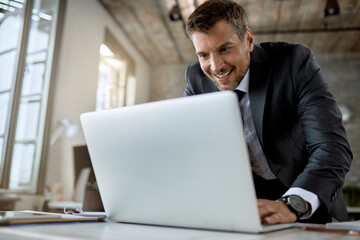 Happy businessman working on a computer in the office.