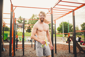 Athlete relaxing after intense workout, drinking water. Young strong sportsman male drinking water from bottle during outdoor fitness workout. care body hydration. sport and health