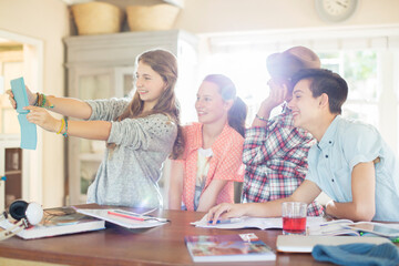 Group of teenagers taking selfie in dining room