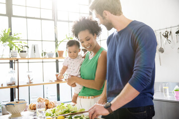 Happy family preparing meal in domestic kitchen