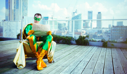 Superhero reading newspaper on city rooftop