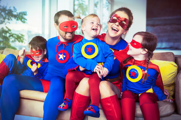 Superhero family laughing on sofa