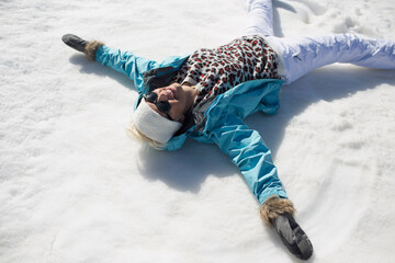Happy woman making snow angels