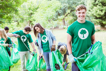 Portrait of smiling environmentalist volunteer picking up trash