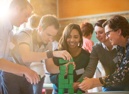 Business people stacking green blocks