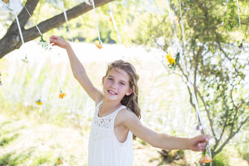 Smiling bridesmaid playing decorations in domestic garden during wedding reception