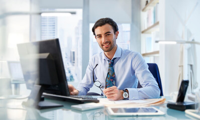 Portrait of man sitting at his desk in office