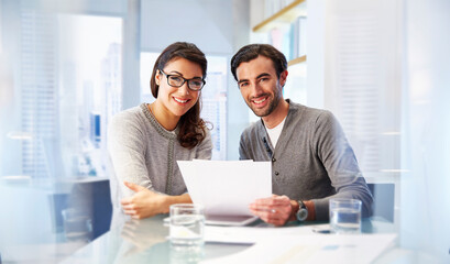 Portrait of man and woman working together in office