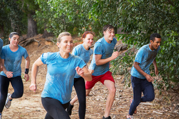 Smiling team running on boot camp obstacle course