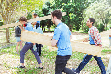Volunteers carrying wood planks