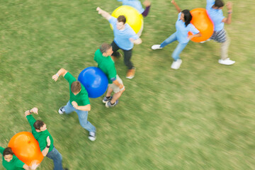 Teammates performing fitness ball team building activity