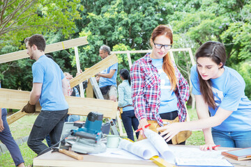 Volunteers reviewing blueprints at construction site