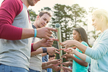 Team balancing pole on fingertips