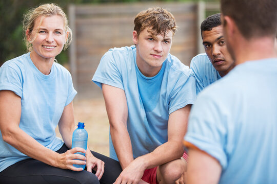 Tired team resting and drinking water at boot camp