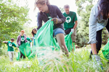 Environmentalist volunteers picking up trash in field