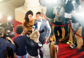 Celebrity couple being interviewed on red carpet