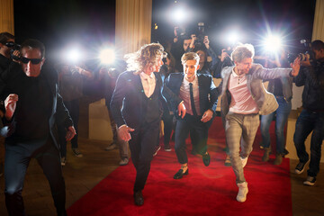 Enthusiastic celebrities arriving running from paparazzi at red carpet event