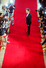 Celebrity being photographed by paparazzi photographers at red carpet event