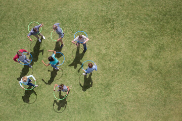 People spinning in plastic hoops in sunny grass © Martin Barraud/KOTO