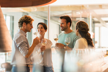 Friends wine tasting white wine in winery tasting room - Powered by Adobe
