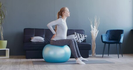 Pregnant woman exercising on fitball at home - Powered by Adobe