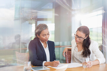 Businesswomen reviewing paperwork in conference room