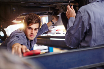 Mechanic reaching for tool in auto repair shop