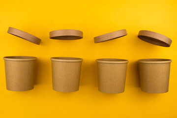 The concept of eco fast food. Soup container with a croup of eco-friendly material on a yellow background close-up with a copy space.